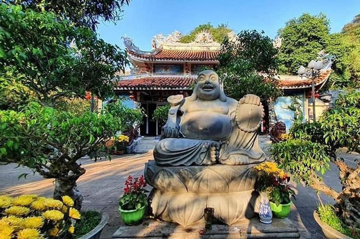 Una gran estatua en un jardín frente a un edificio.