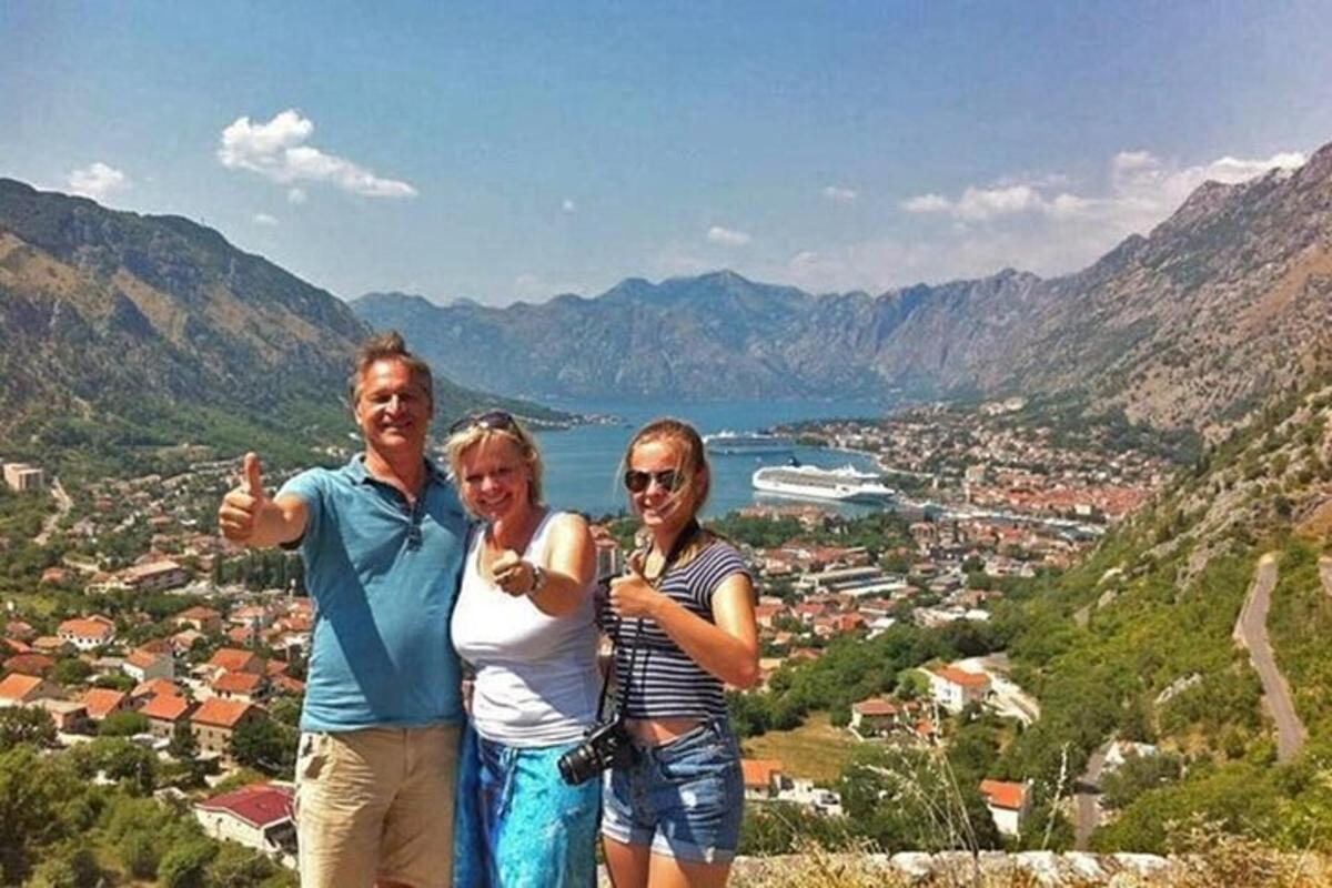 a group of three people standing on top of a mountain
