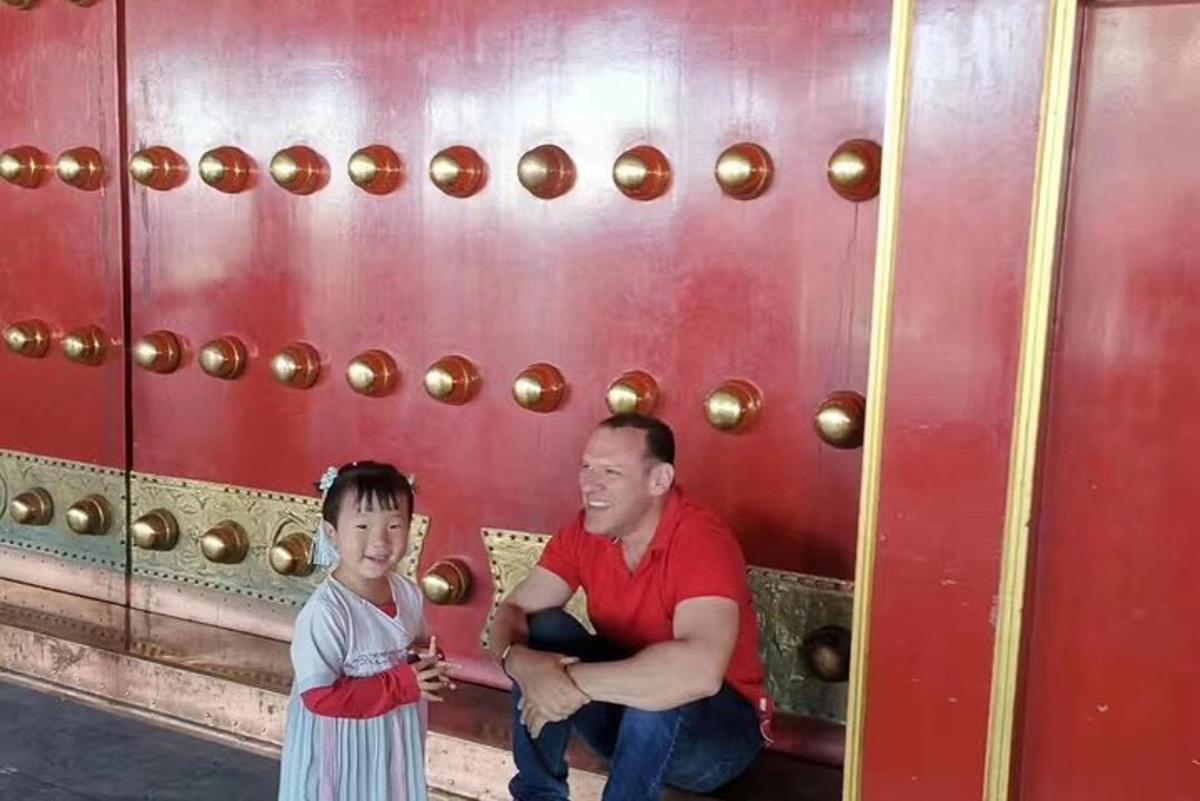 Un hombre y un niño sentados junto a una pared