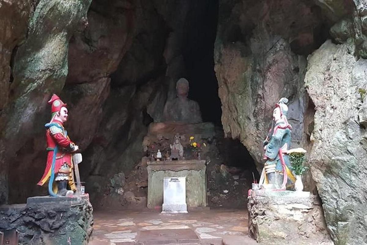 een tempel met beelden in een grot met een groot standbeeld