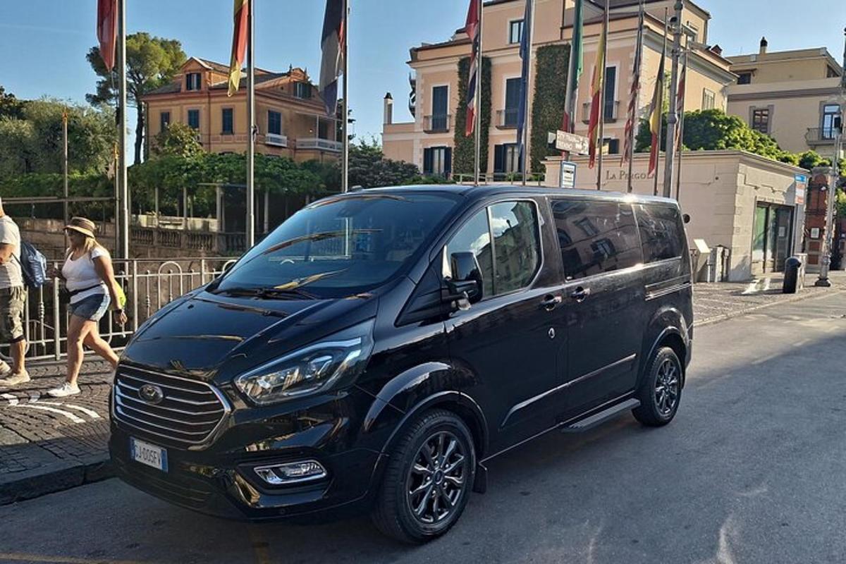 uma van preta estacionada na beira de uma rua
