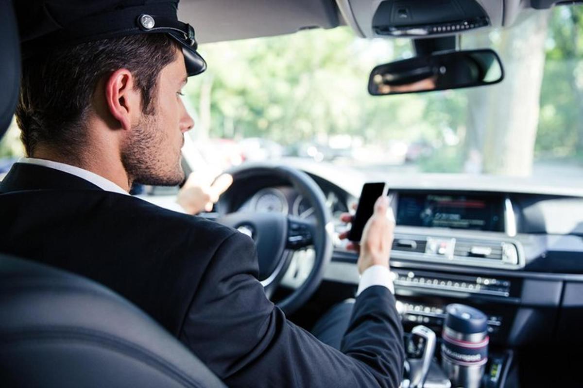 a man driving a car while looking at a cell phone