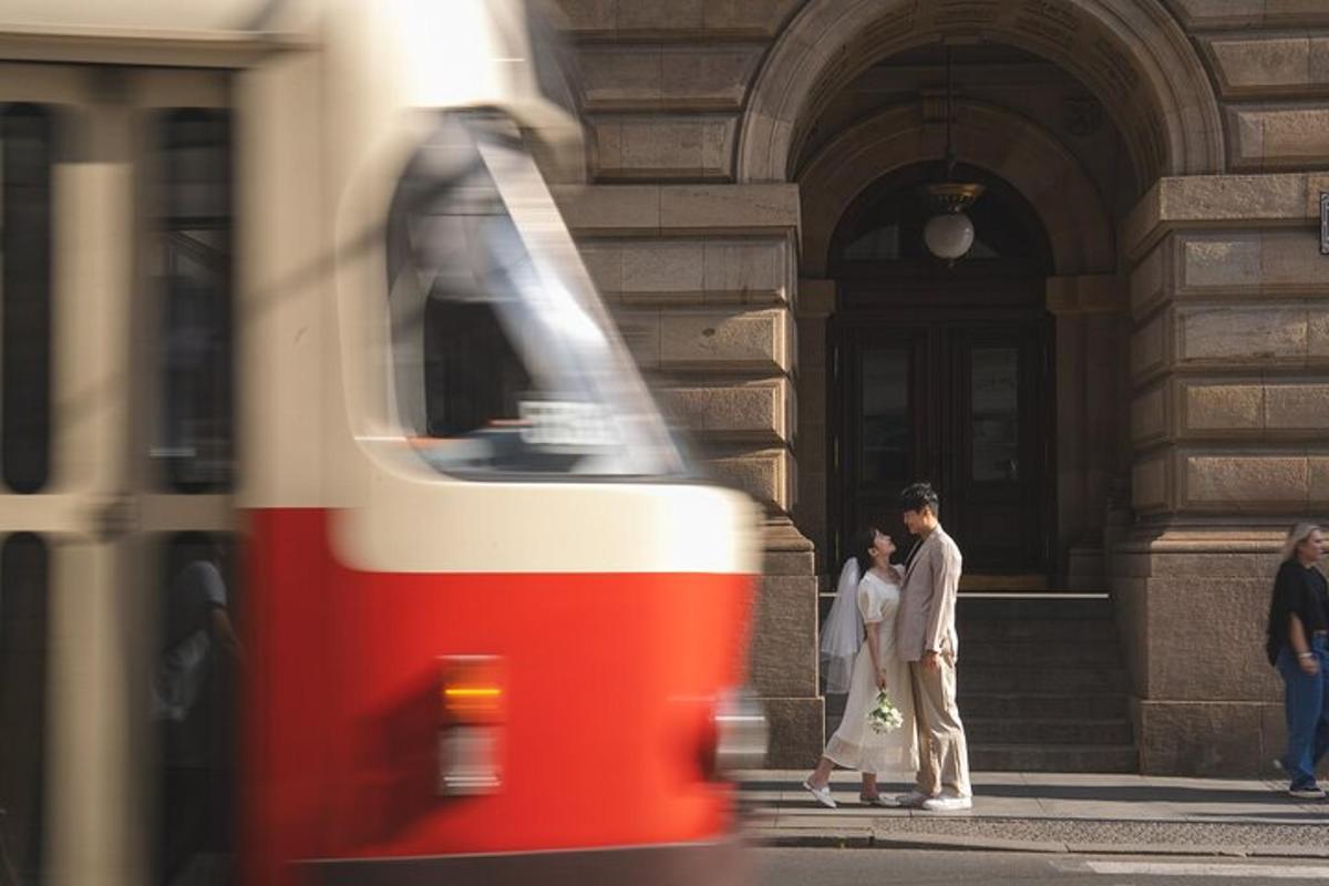 dwie osoby stojące przed budynkiem z pociągiem