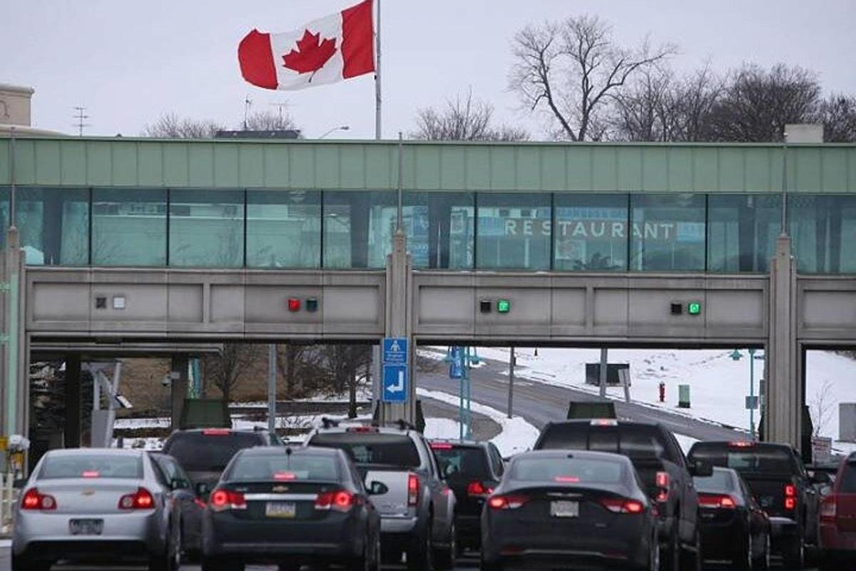 a highway filled with lots of traffic with a canadian flag
