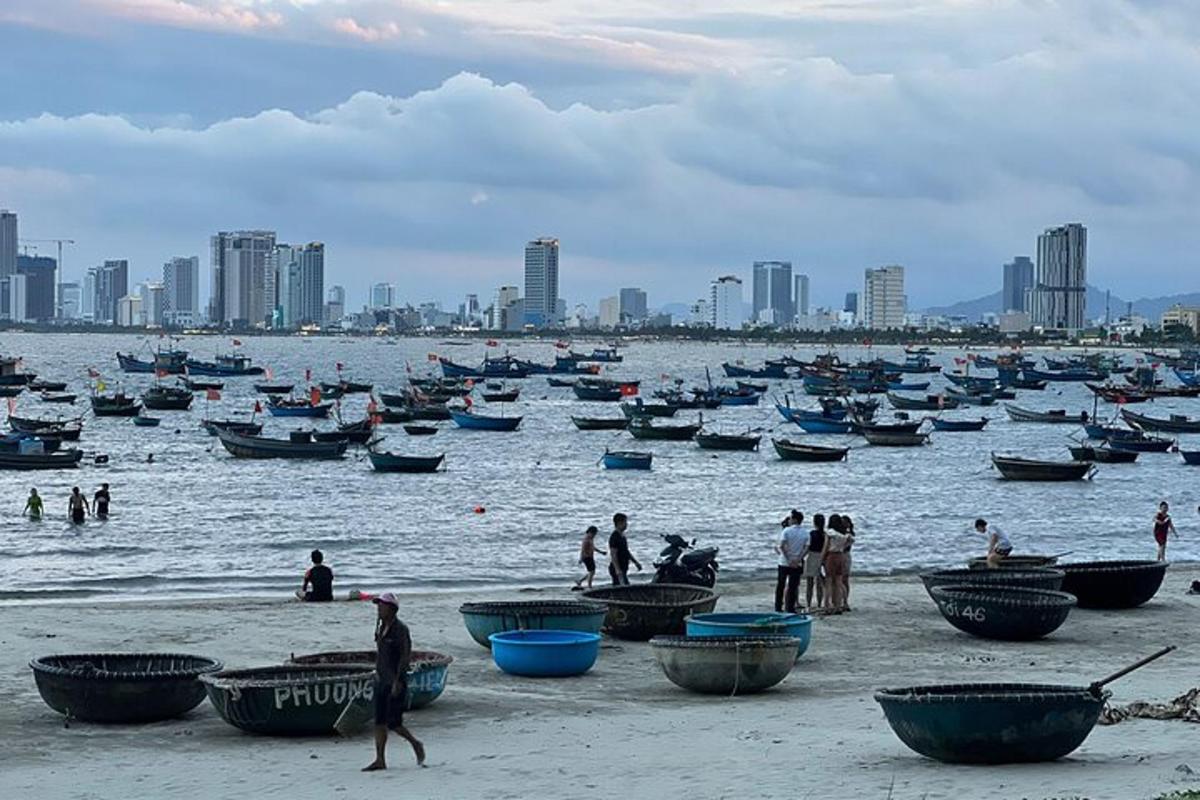 sekelompok orang di pantai dengan perahu di air