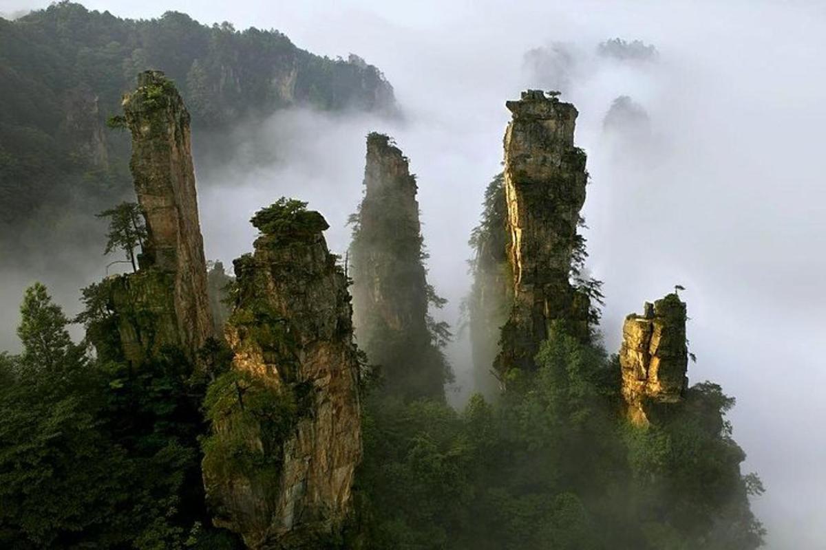 a group of tall rock formations in the mist