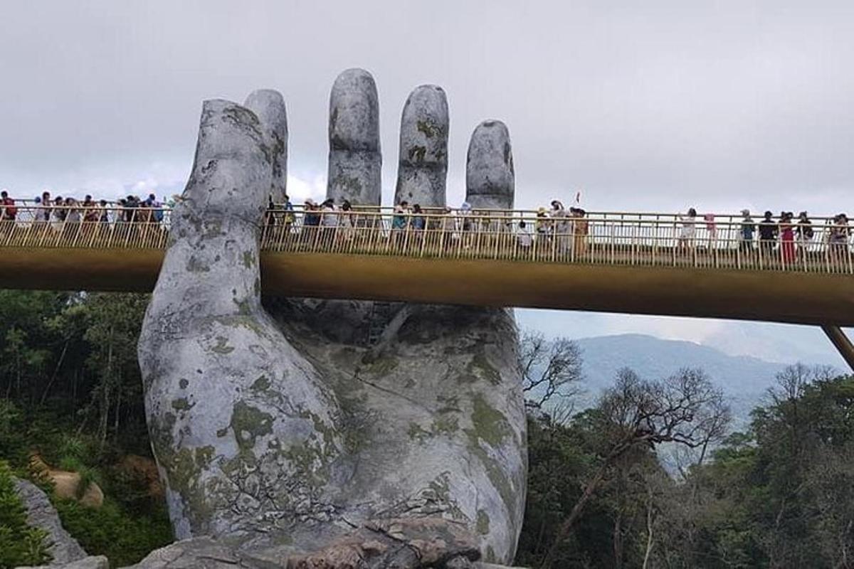 un ponte con una grande mano che sorregge un ponte sopra una roccia