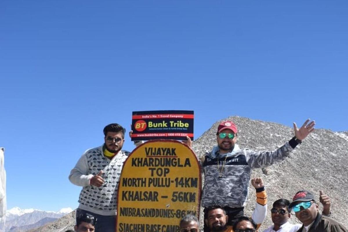 a group of people holding a sign in the mountains