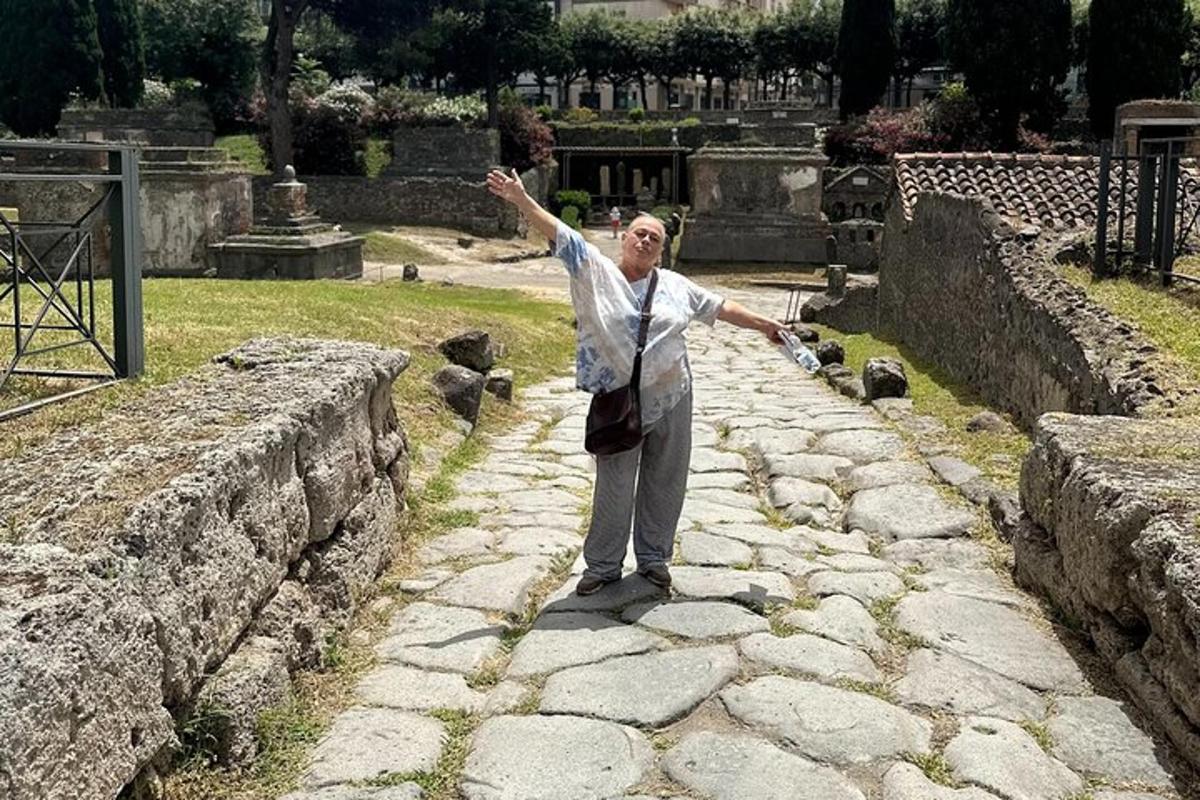 muž stojící na kamenné zdi s rozpaženýma rukama