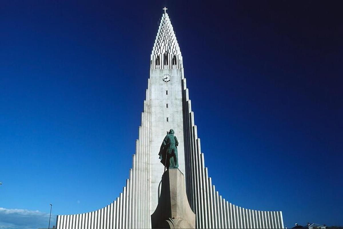 a tall white building with a statue in front of it