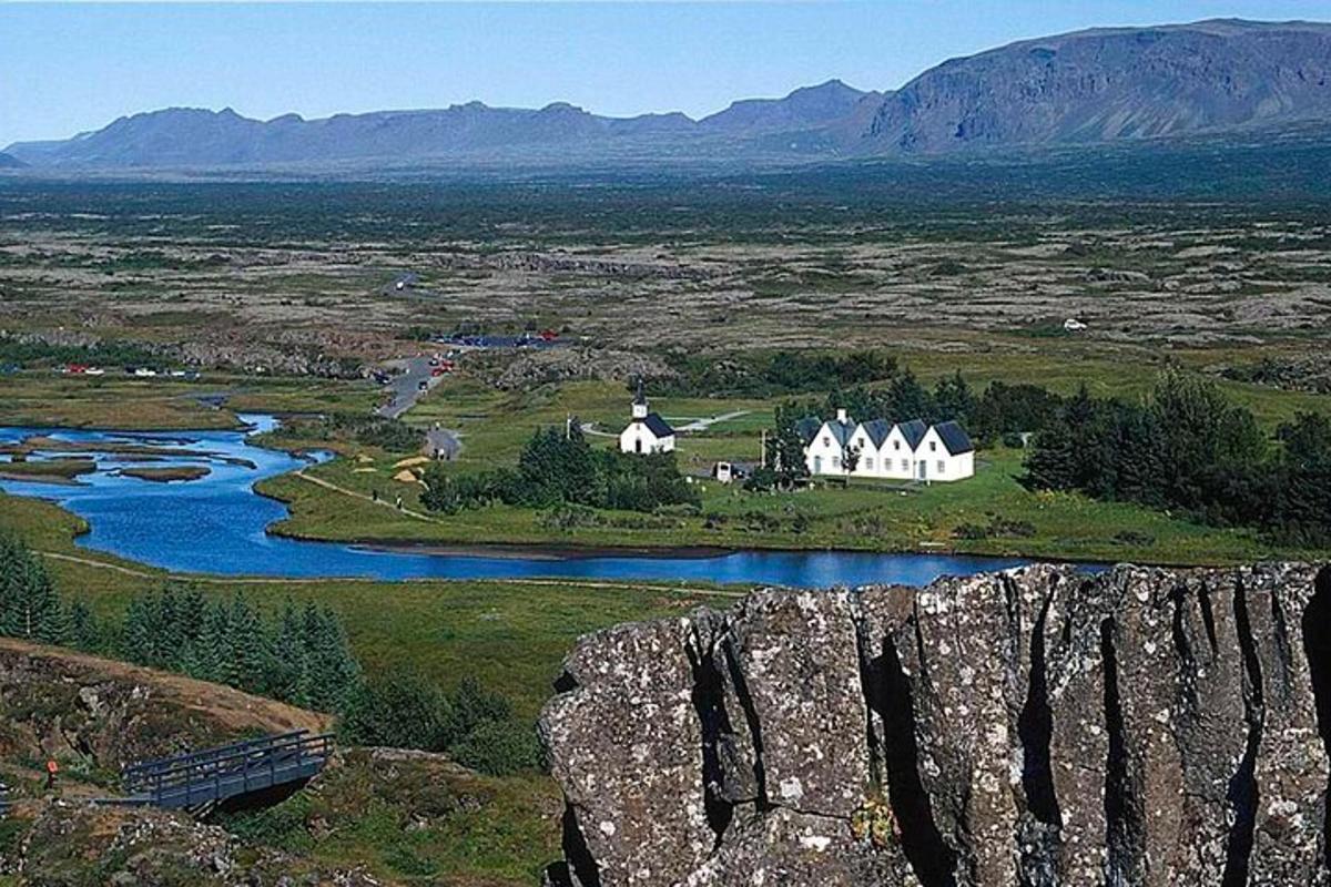 a house on a hill next to a river