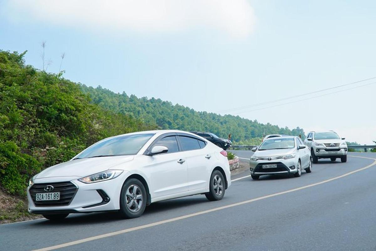 sebuah mobil putih melaju di jalan raya dengan mobil-mobil lain