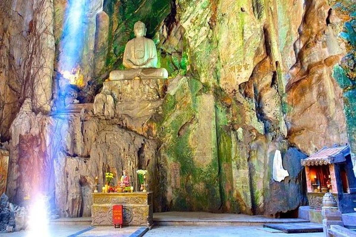 sebuah kuil Buddha dengan patung di dinding batu