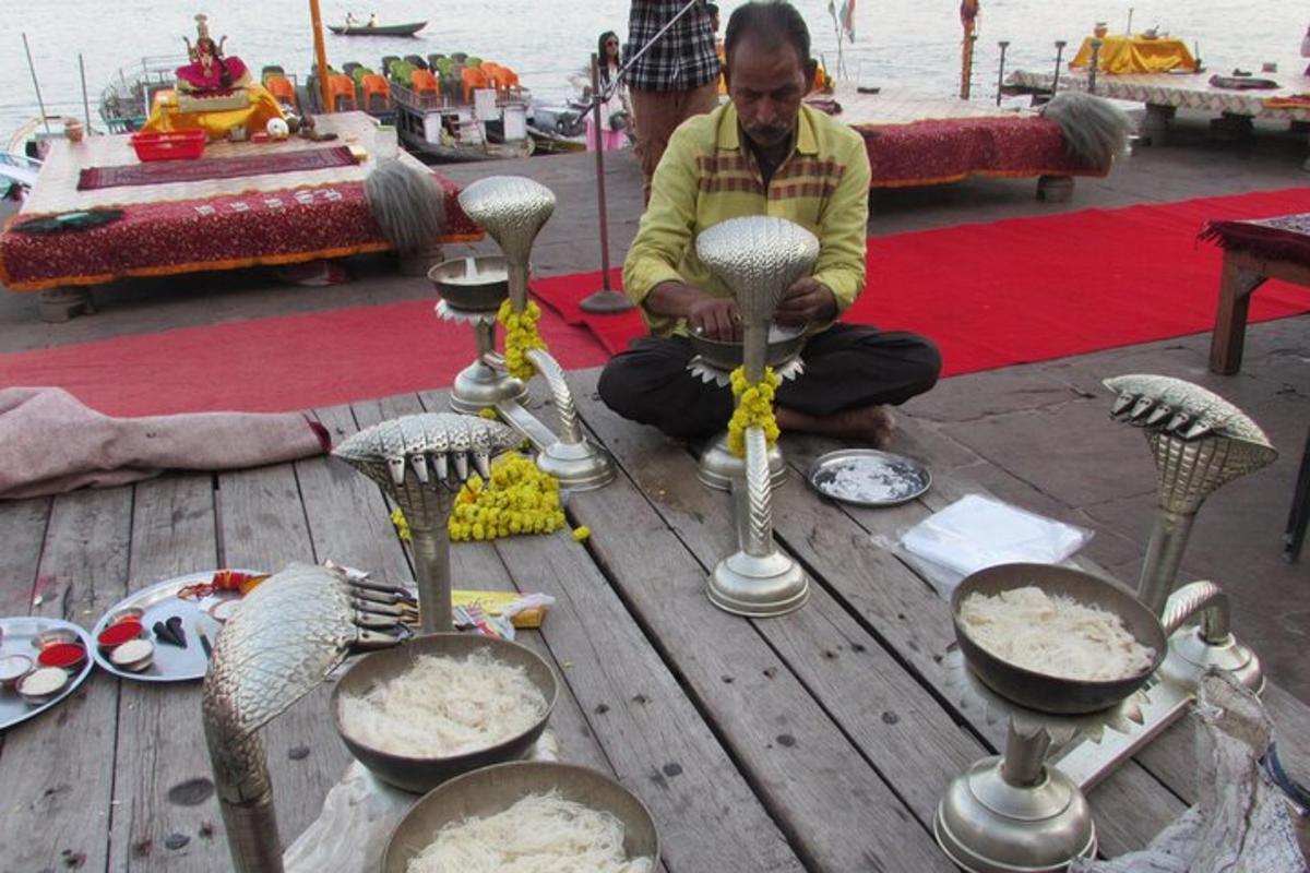 một người đàn ông đang ngồi trên một chiếc bàn gỗ với nhiều thìa