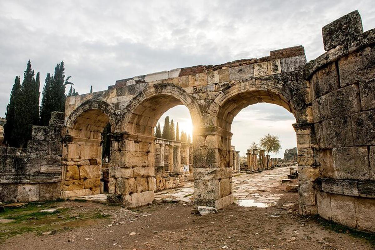 un vecchio edificio in pietra con due archi in un campo