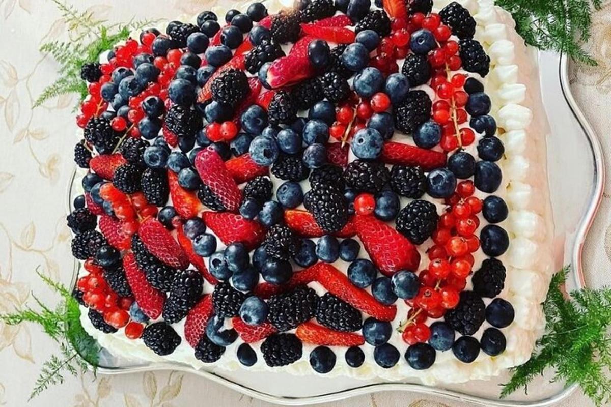 Un pastel con la bandera estadounidense y bayas encima.