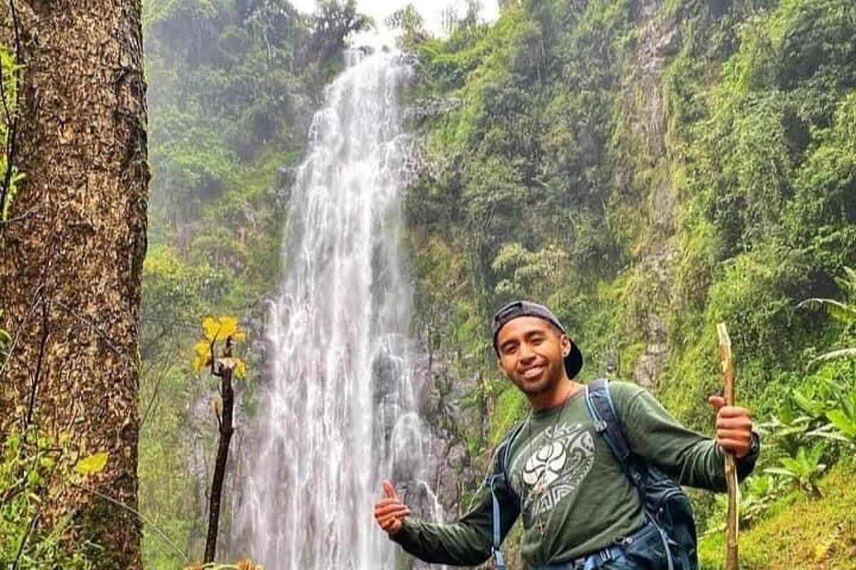 un hombre parado frente a una cascada