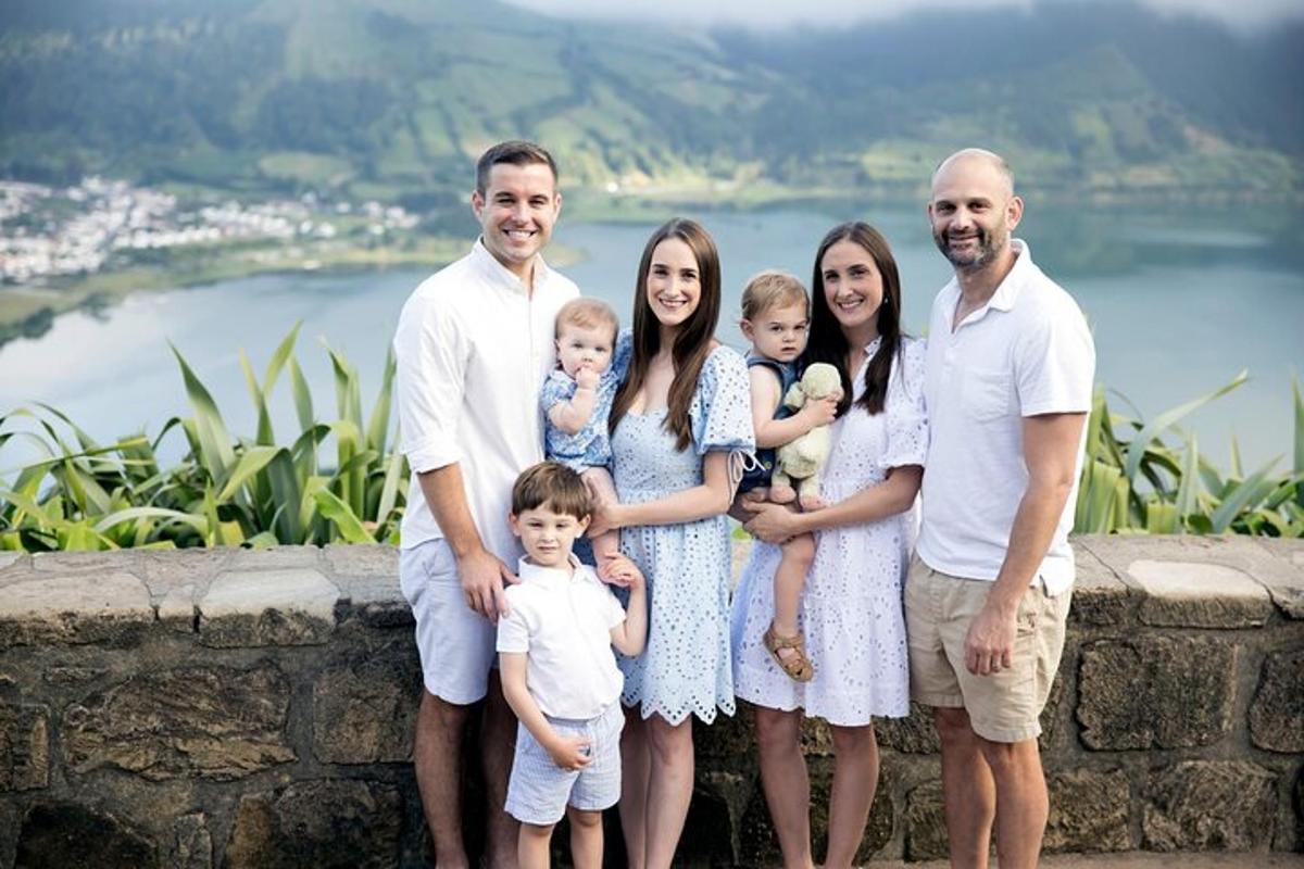 o familie care pozează pentru o fotografie în fața unui perete