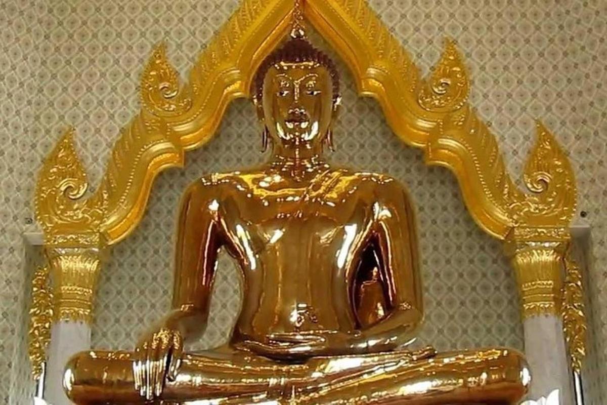 una statua di Buddha d'oro seduta su un tavolo
