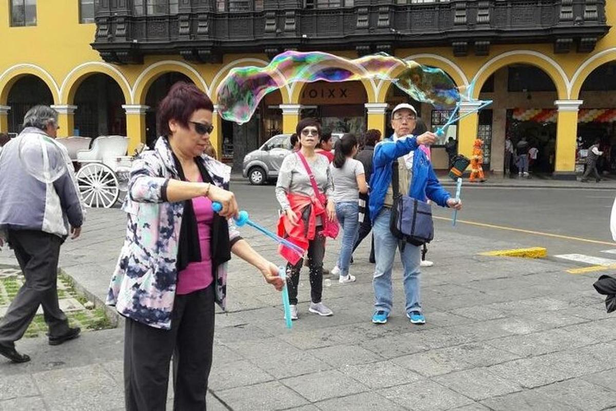 a group of people walking down a street with an umbrella