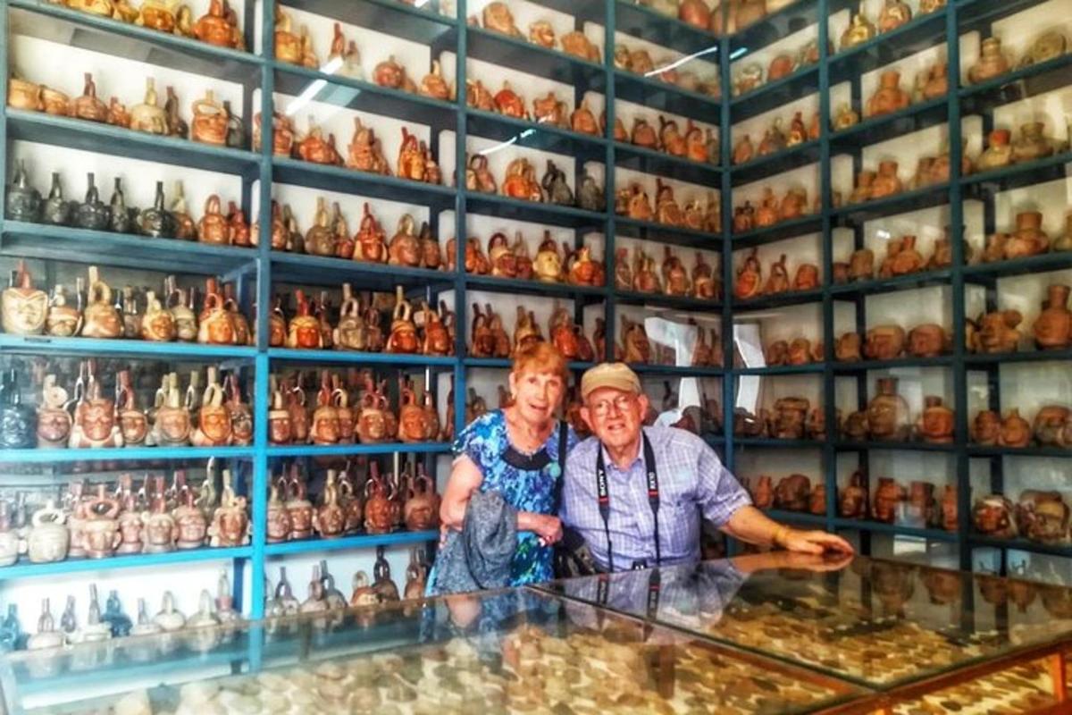 two people standing behind a counter in a room full of vases