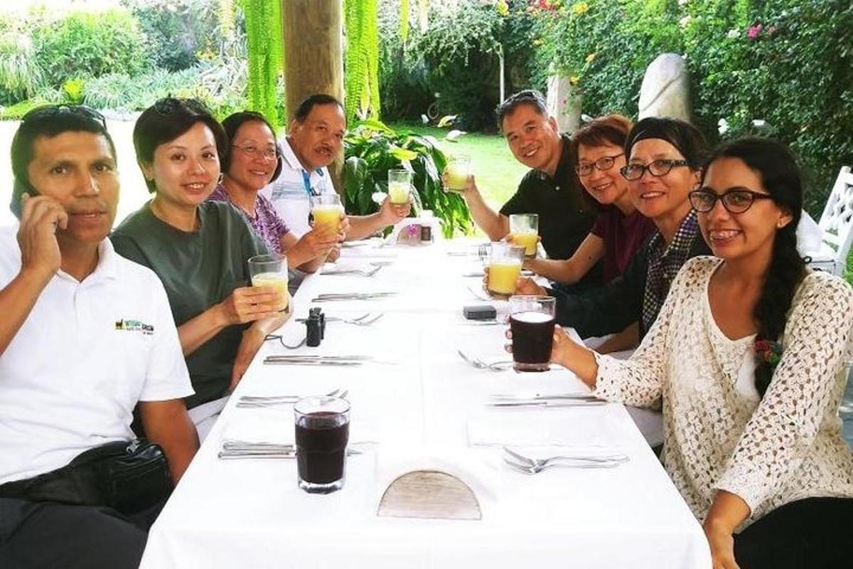 a group of people sitting at a long table with drinks
