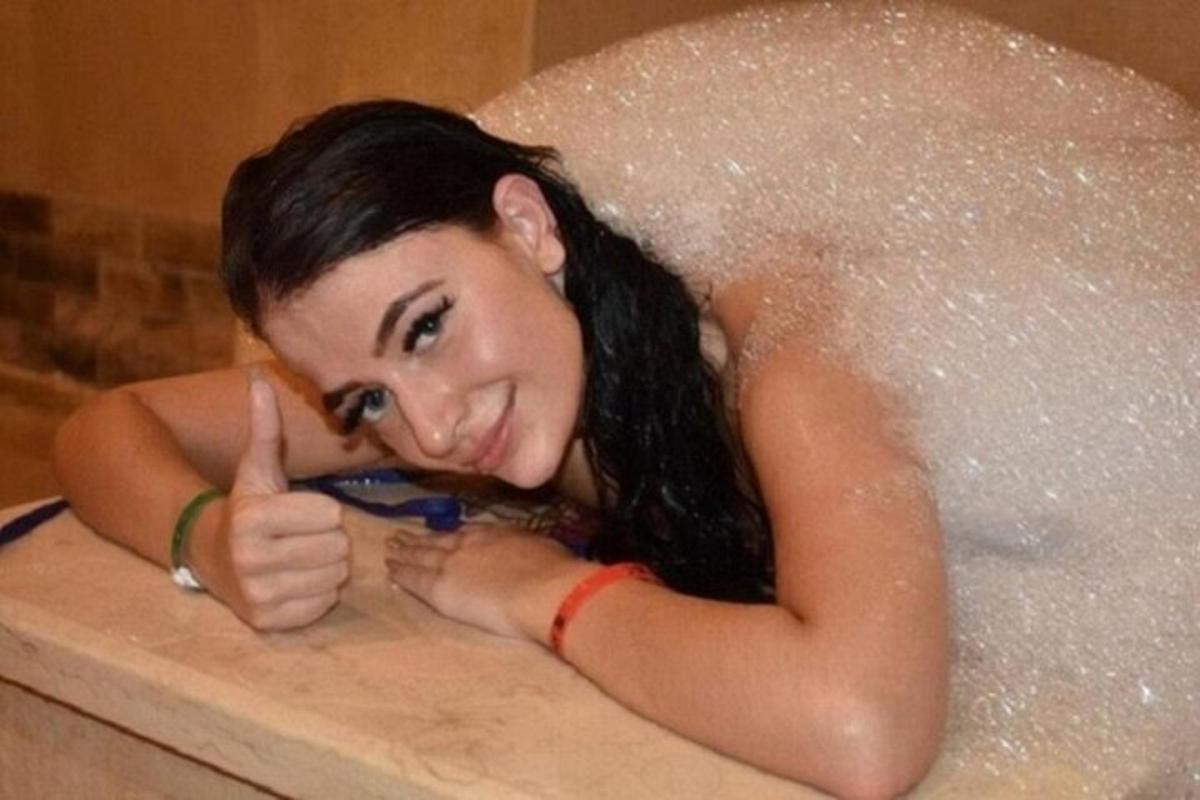 una donna in una vasca da bagno che fa un gesto di pollice in su