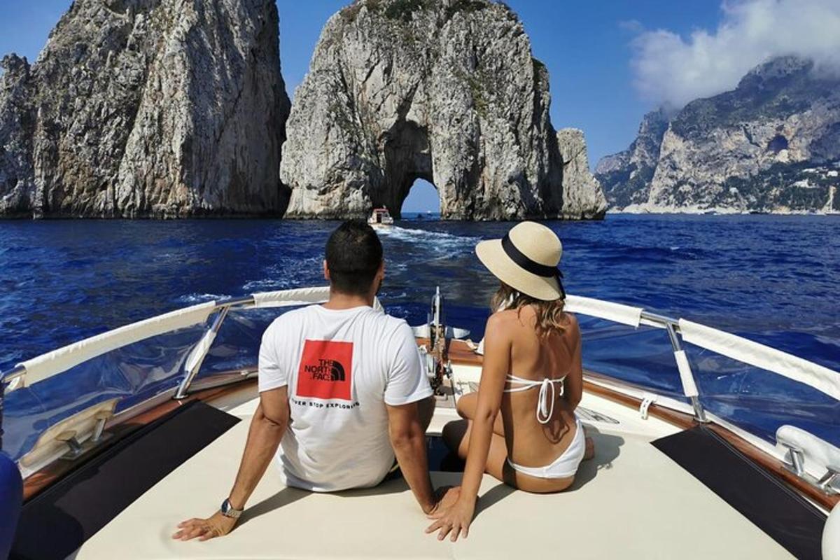 un uomo e una donna seduti su una barca di fronte a una grotta