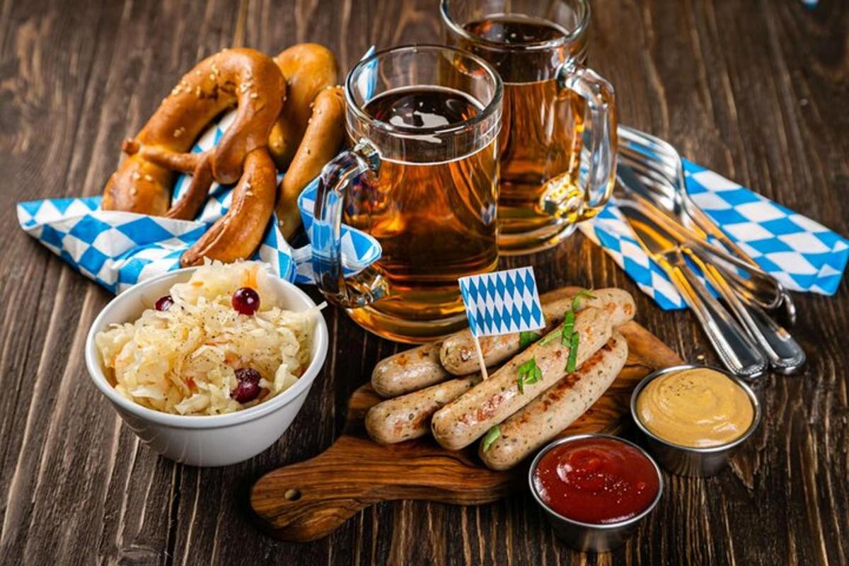stůl s talířem jídla s preclíky a pivem