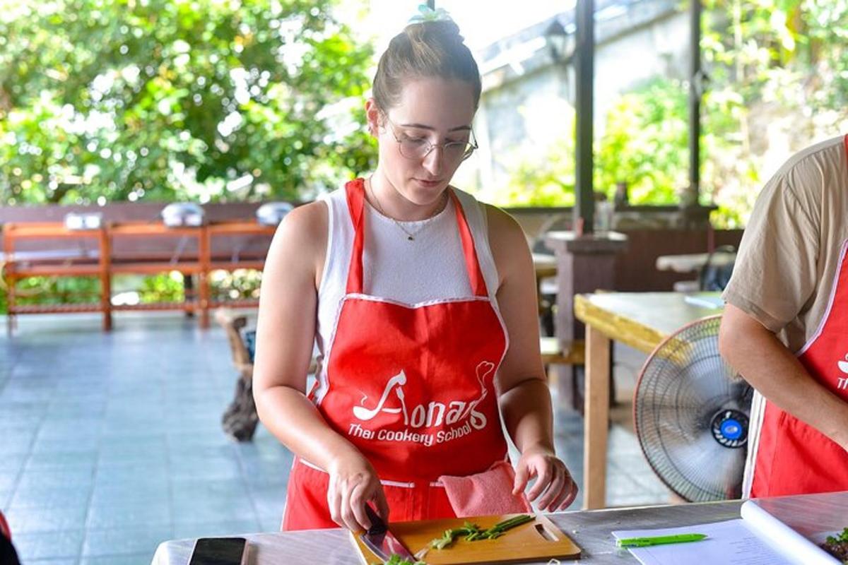 una donna con un grembiule rosso che prepara il cibo a un tavolo