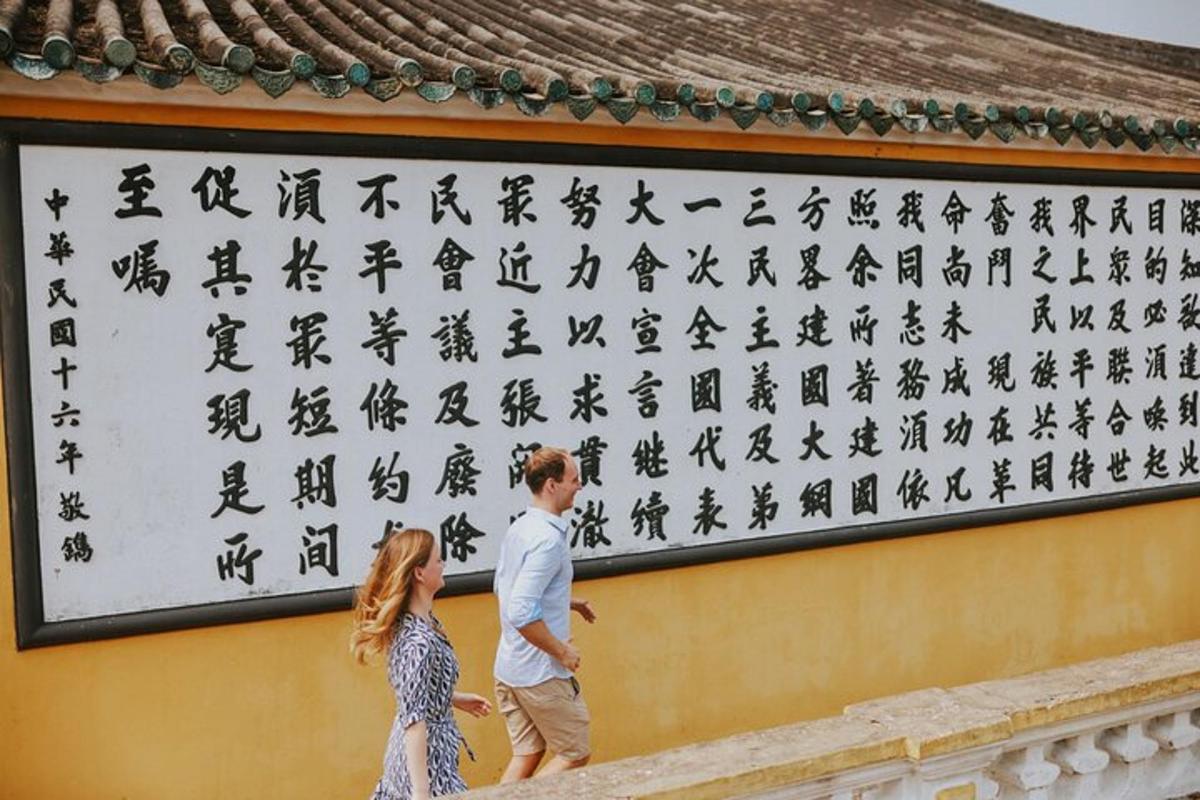 un uomo e una donna in piedi davanti a un muro con geroglifici