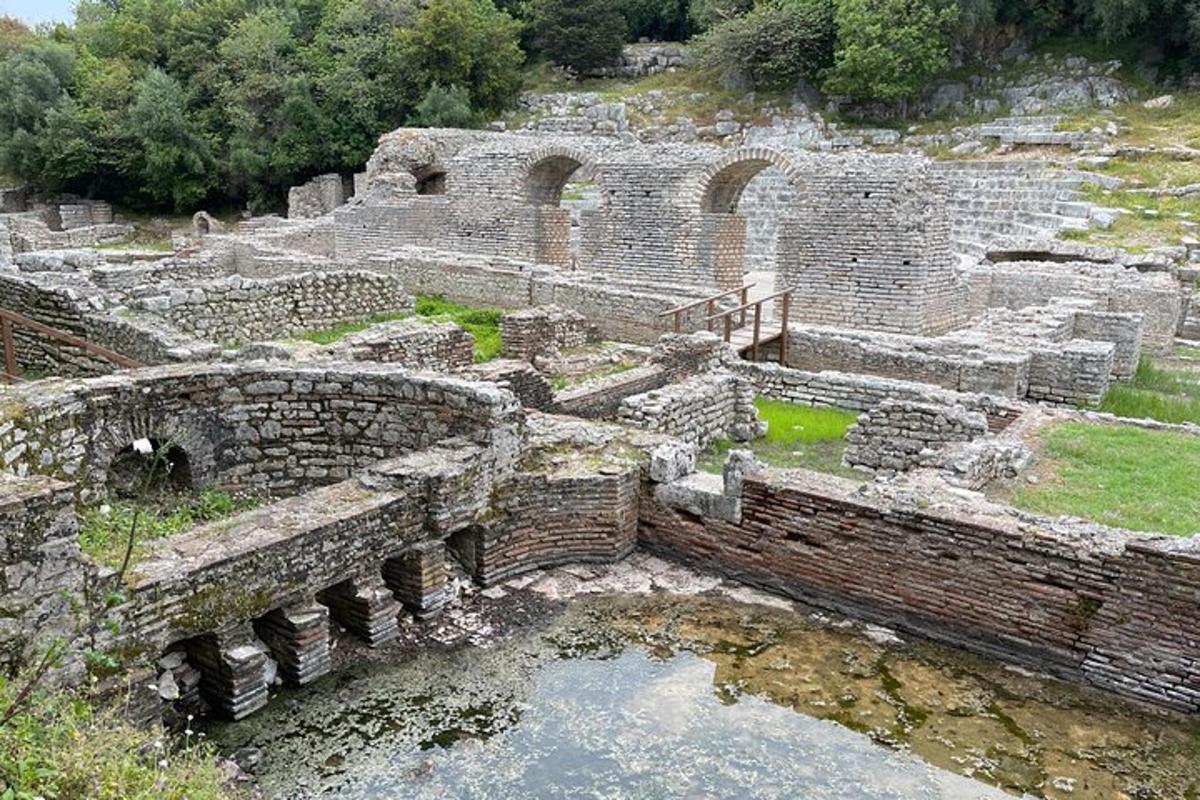 Un antiguo anfiteatro con un estanque de agua en su interior.