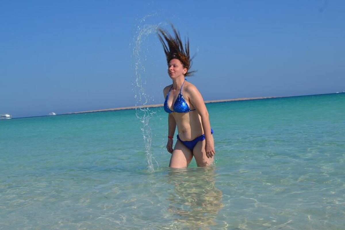 uma mulher parada na água do oceano