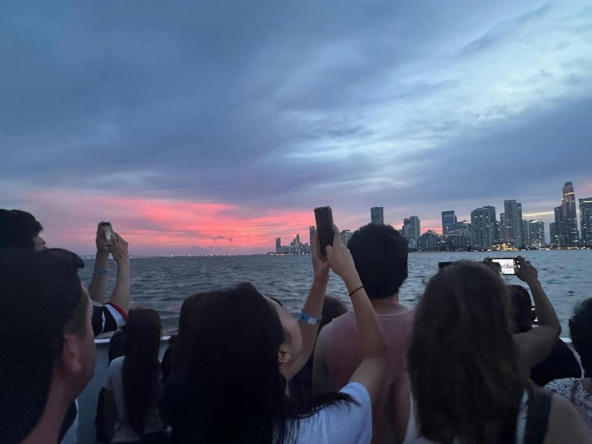 um grupo de pessoas tirando fotos da cidade de um barco