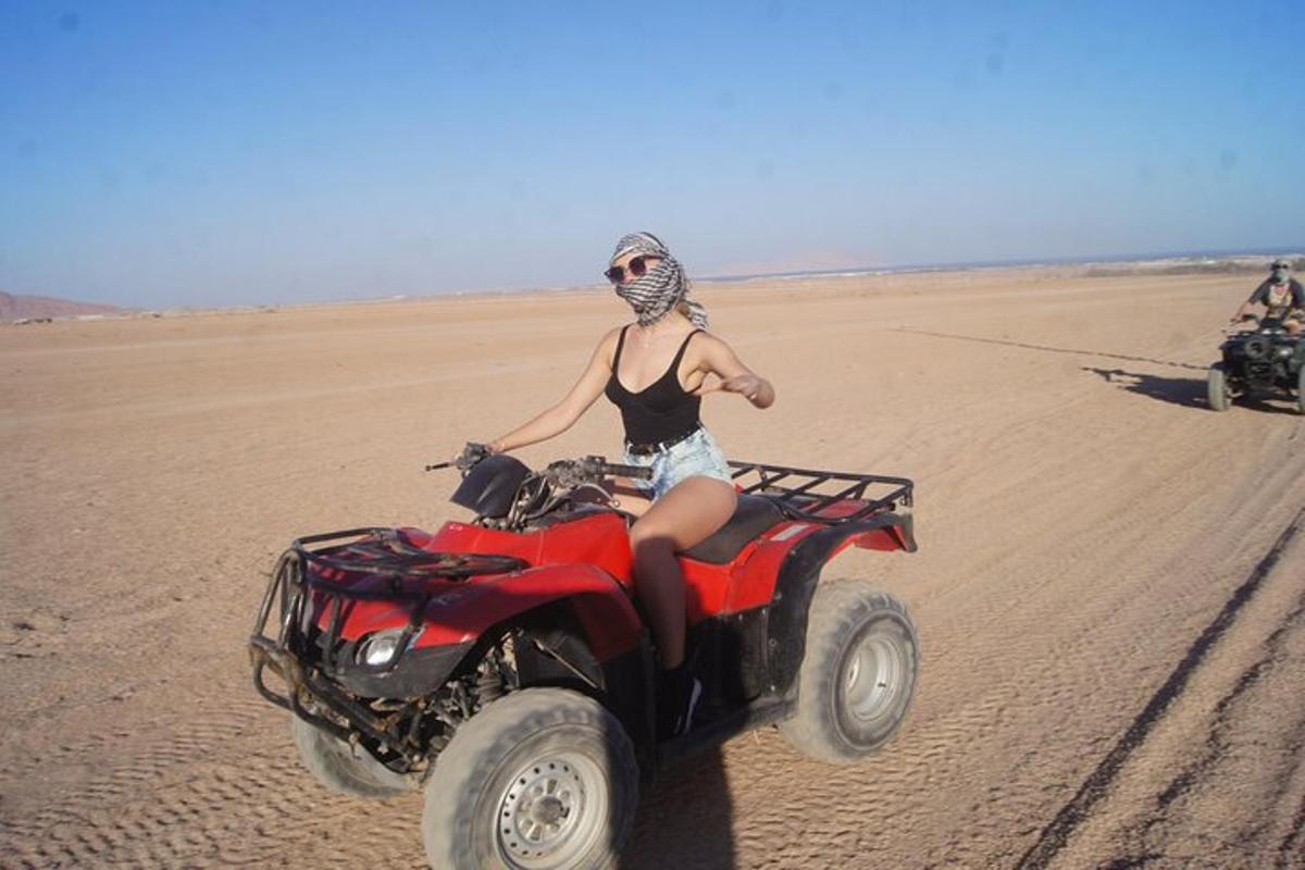 uma mulher andando de quadriciclo no deserto
