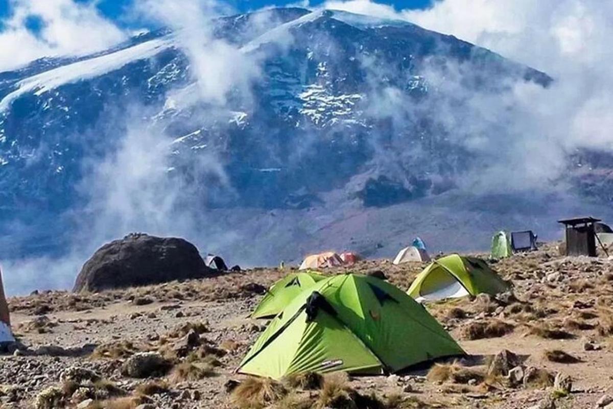 en gruppe telt og et fjell i bakgrunnen
