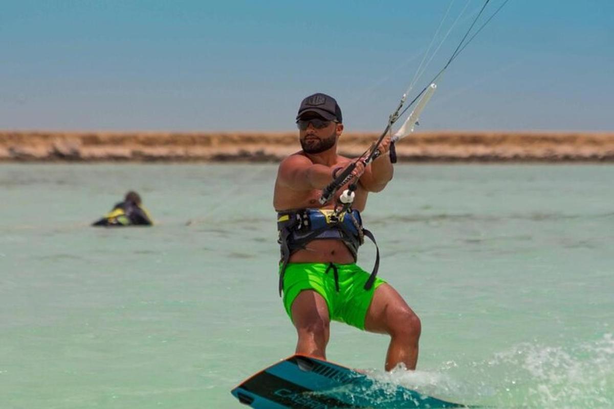 un uomo in pantaloncini verdi su una tavola in acqua