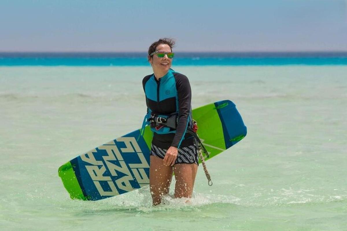 un uomo che cammina nell'acqua con una tavola da surf