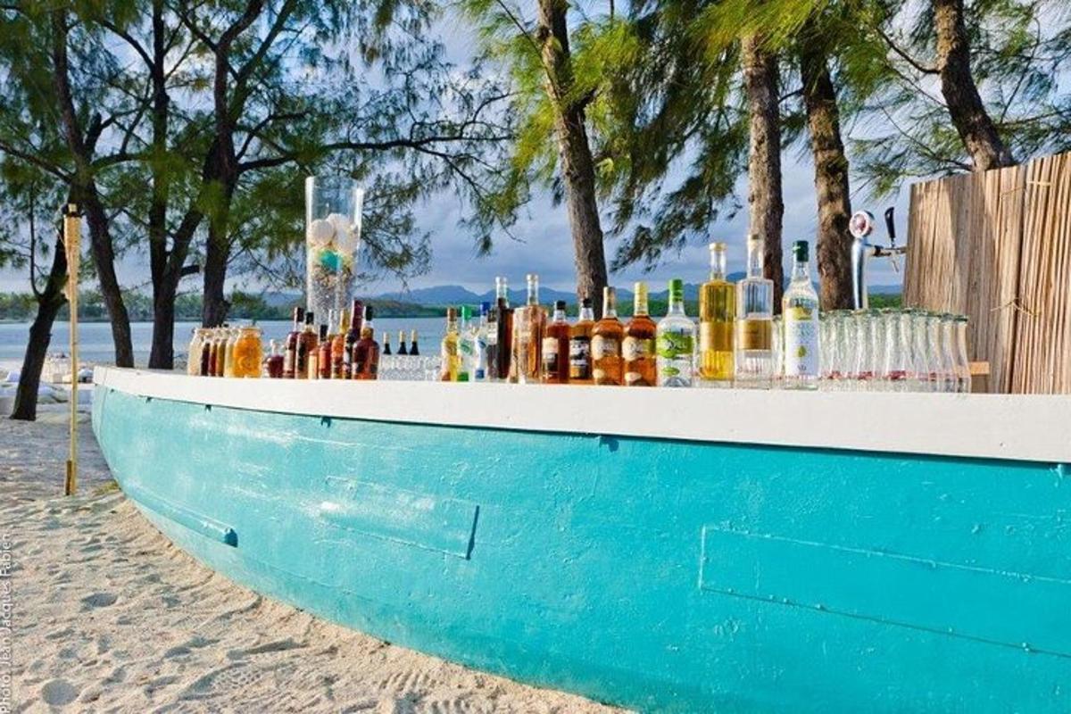 bar na plaži s bocama na njemu