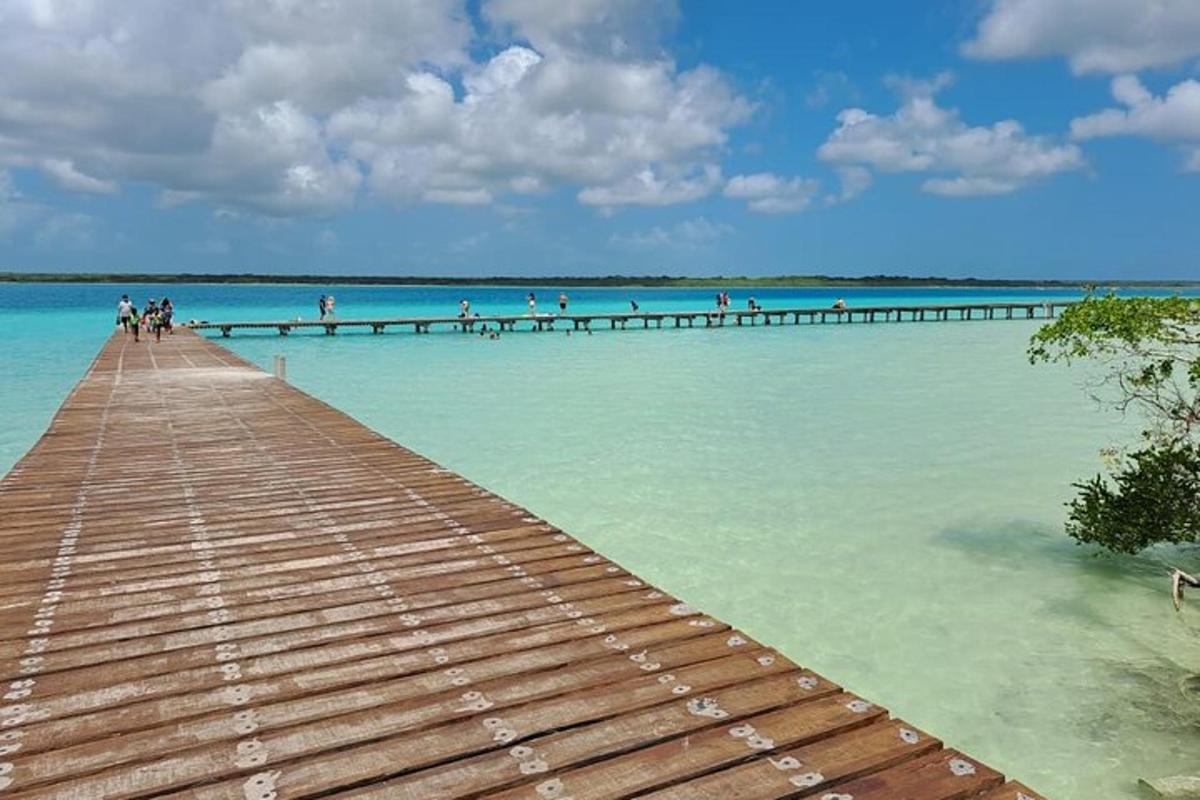 a wooden pier in the water with people on it