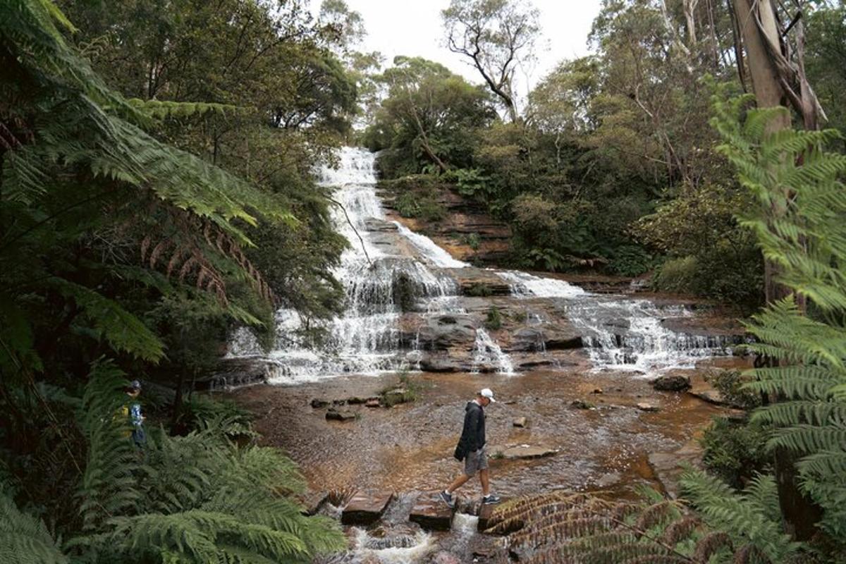 a man standing in front of a waterfall