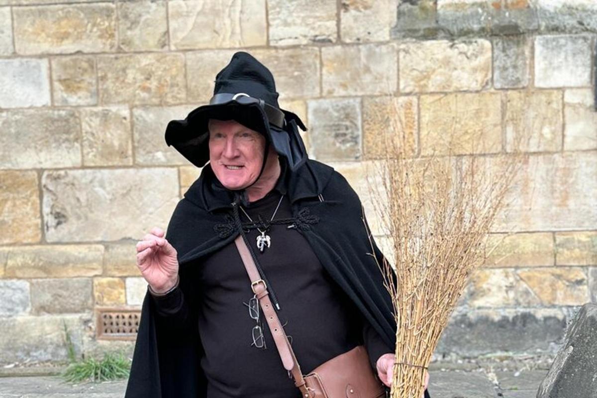 a man in a witch outfit holding a broom
