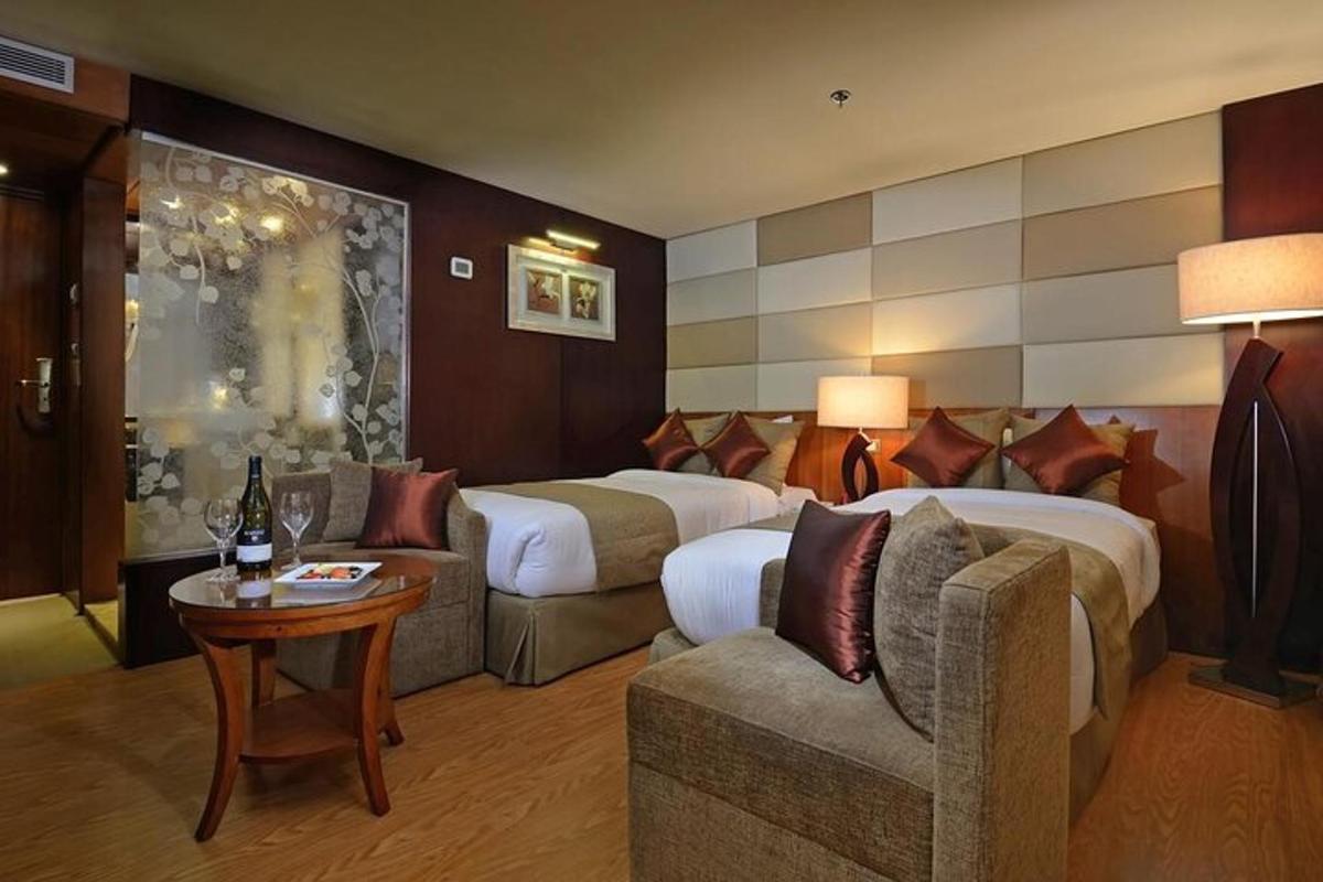 kamar hotel dengan tiga tempat tidur dan sofa
