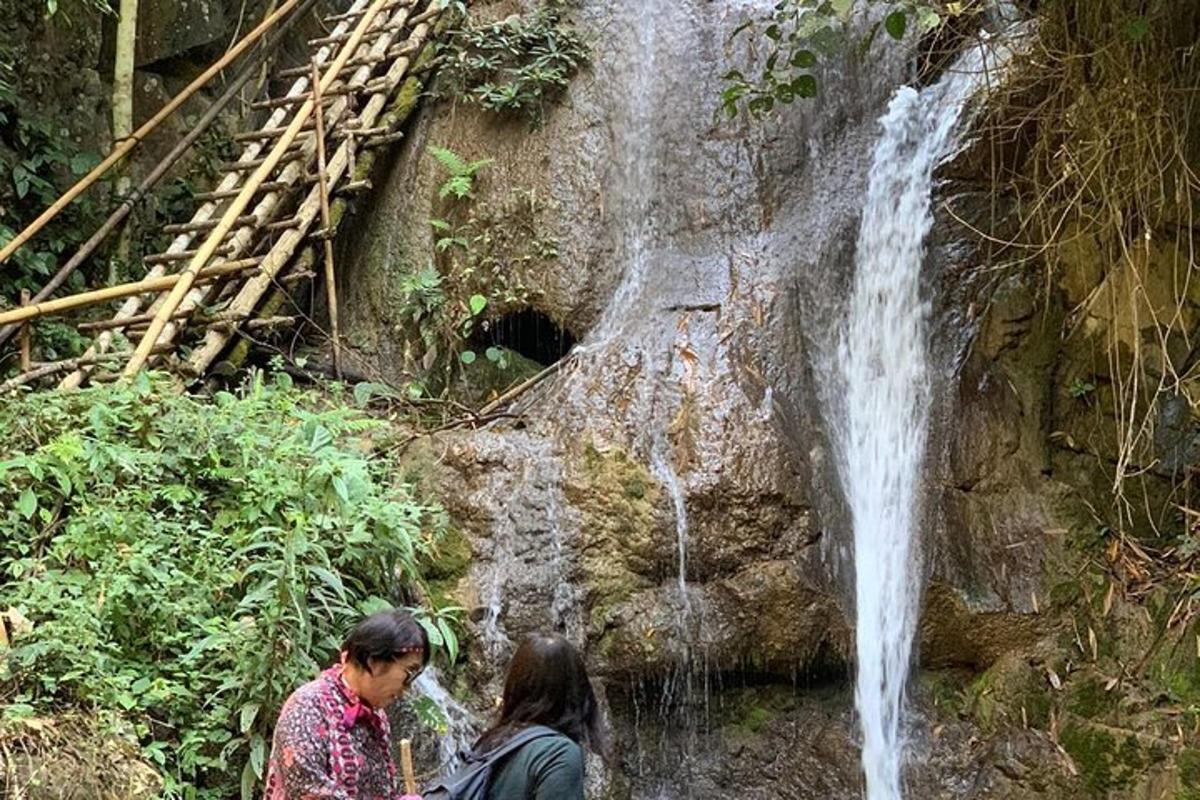 two people standing in front of a waterfall