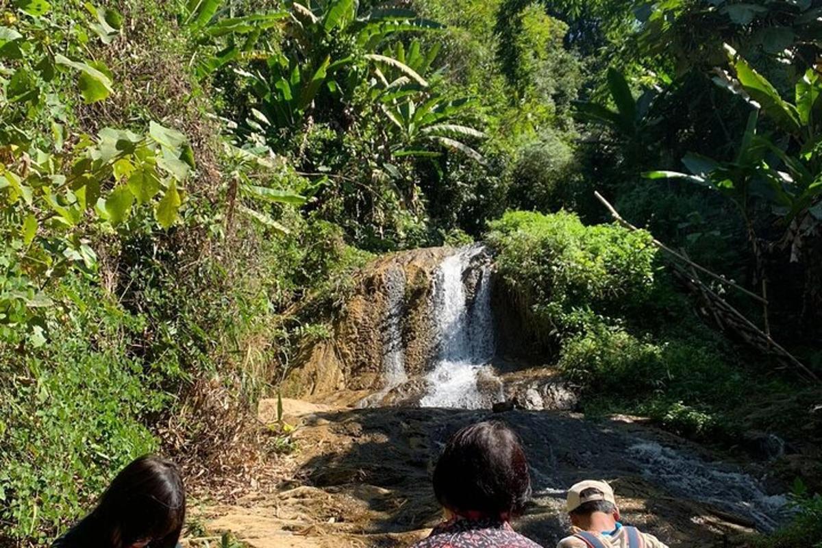 a group of people sitting in front of a waterfall