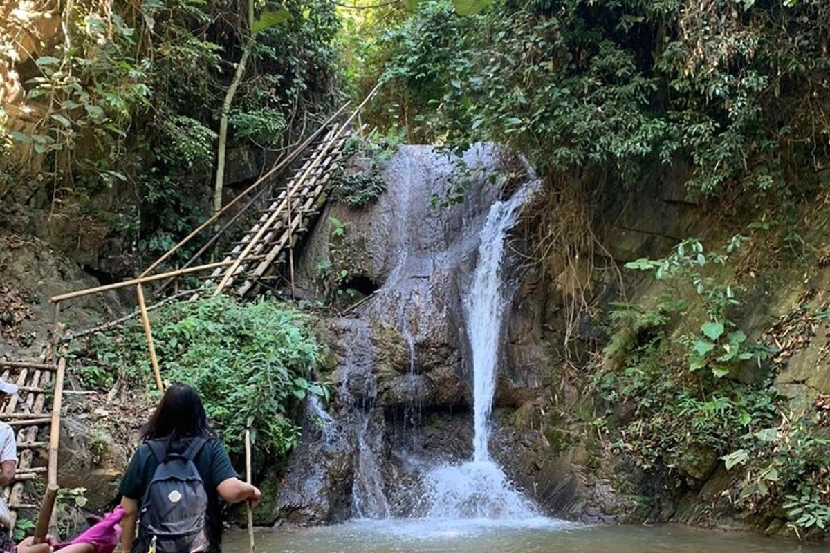 a woman is standing in front of a waterfall