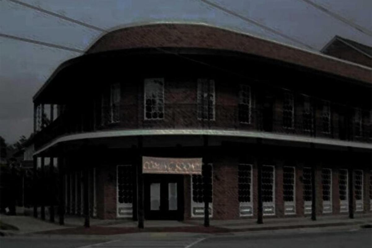 a brick building with a sign in front of it