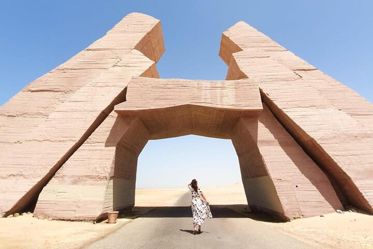 uma mulher em pé em frente a um arco no deserto