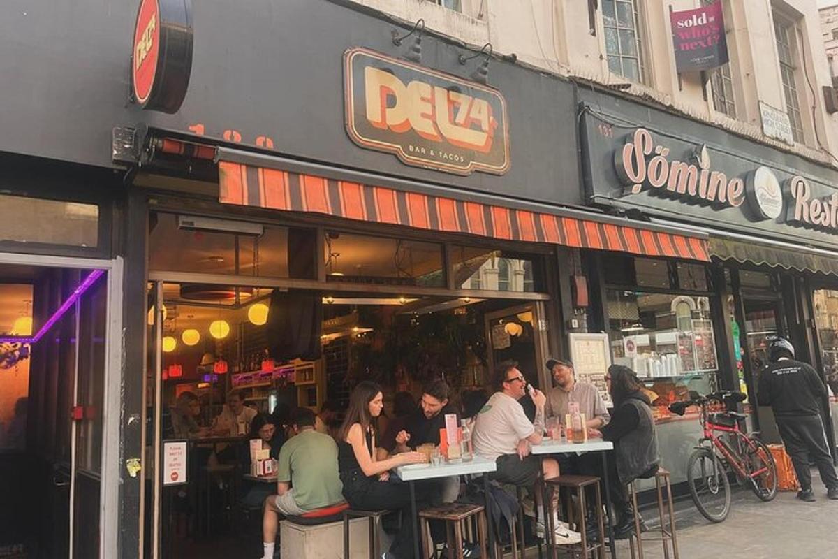 Un grupo de personas sentadas en mesas afuera de un restaurante.