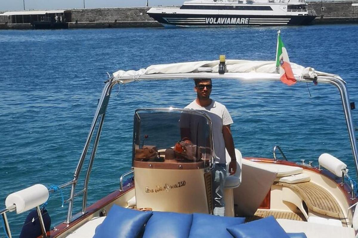 Un hombre parado en la parte trasera de un bote en el agua.